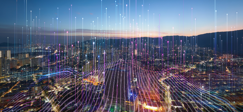 Vista aérea de cidade inteligente iluminada por feixes de dados da Conectividade 5G e 6G.