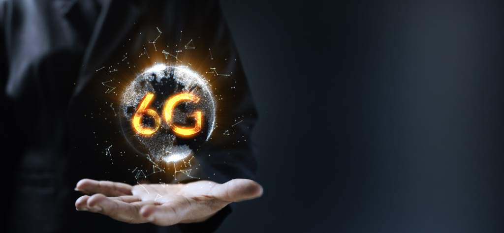 Mão segurando um globo digital iluminado com o símbolo da Conectividade 5G e 6G.