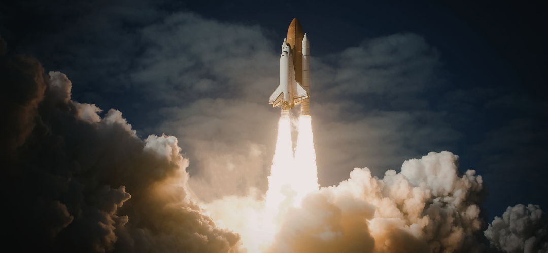 Fotografia de um ônibus espacial decolando entre nuvens de fumaça e fogo, representando um marco na Corrida espacial moderna.