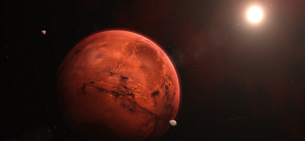 O Planeta Vermelho
Superfície: O planeta exibe uma coloração rica em tons de terracota, ferrugem e laranja escuro.

Geografia: É possível observar claramente grandes formações que lembram o Valles Marineris (o vasto sistema de cânions) cortando a região central, além de várias crateras de impacto espalhadas pela superfície.

Atmosfera: Uma leve névoa ou brilho atmosférico contorna a borda do planeta, onde a luz solar atinge a curvatura.